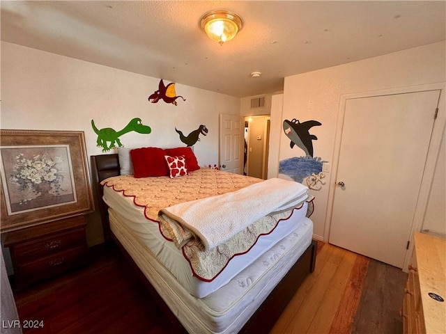 bedroom with wood finished floors and visible vents