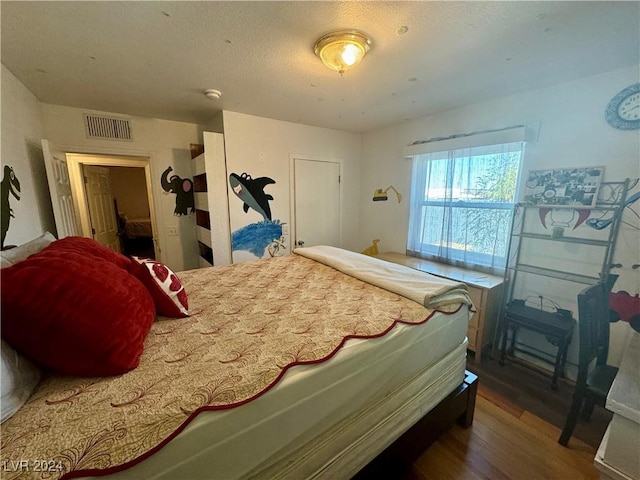 bedroom with visible vents and wood finished floors