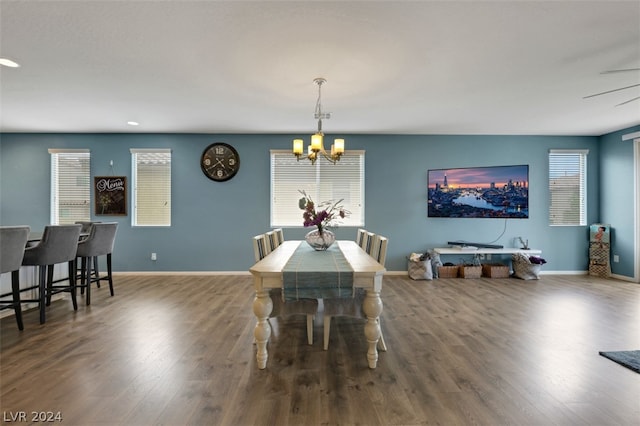 dining area with hardwood / wood-style floors and an inviting chandelier