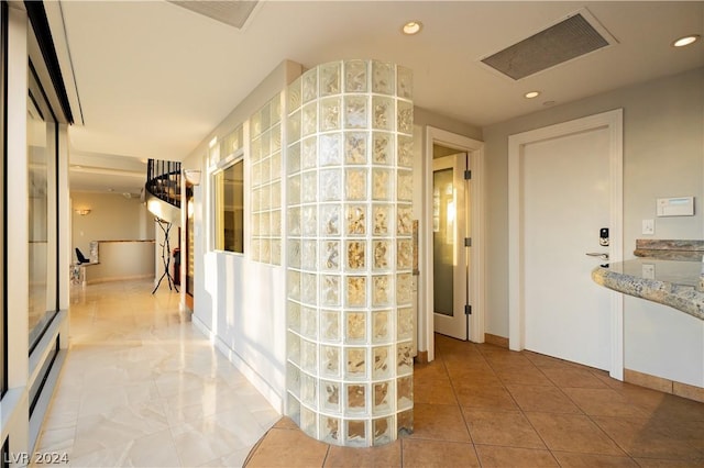 hallway featuring light tile patterned floors, visible vents, and recessed lighting