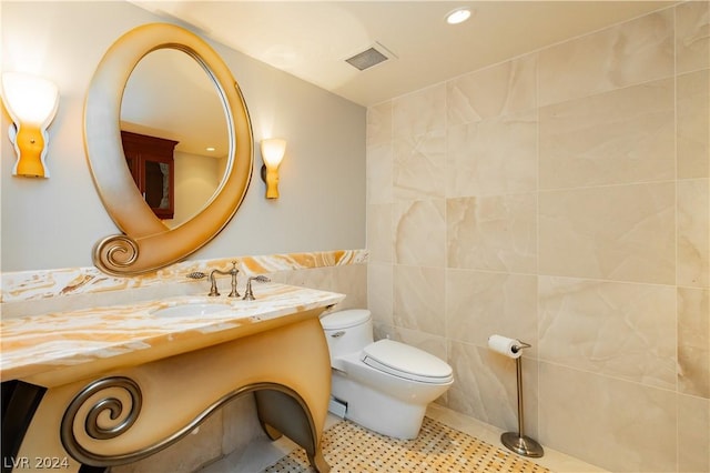 bathroom with tile patterned flooring, toilet, visible vents, vanity, and tile walls