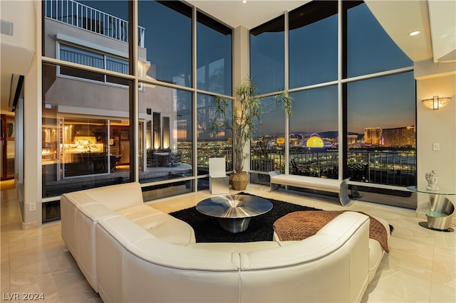 living room with a high ceiling and floor to ceiling windows