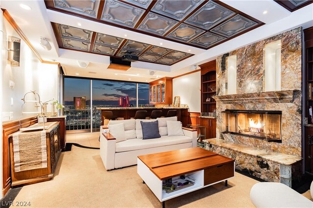 carpeted living room featuring crown molding and a premium fireplace