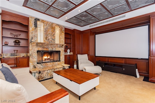 home theater room with light carpet, a premium fireplace, and built in shelves