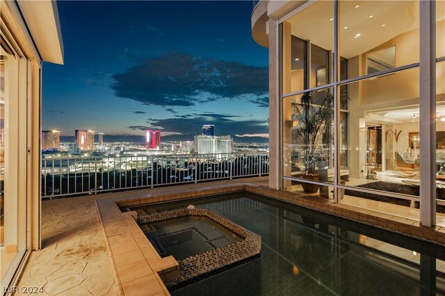 balcony at dusk with an in ground hot tub