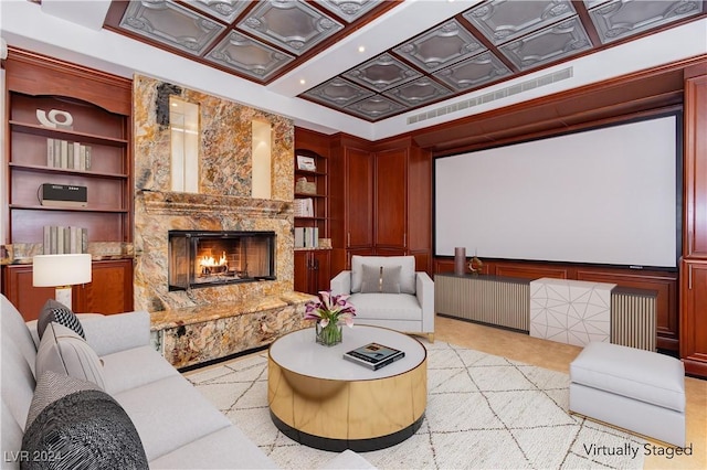 home theater featuring a fireplace, built in features, coffered ceiling, and light colored carpet