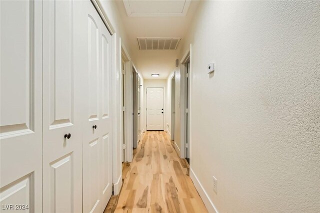 corridor with light hardwood / wood-style floors