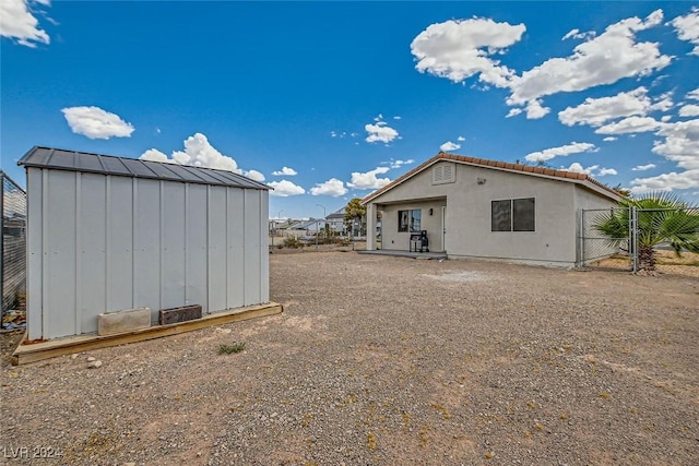 back of property featuring a storage unit