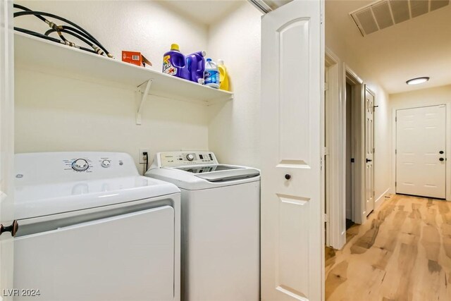 laundry area featuring separate washer and dryer and light wood-type flooring