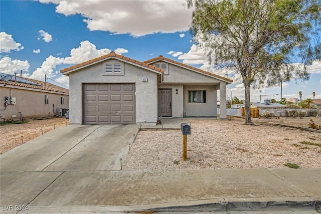 view of front of property featuring a garage and central AC