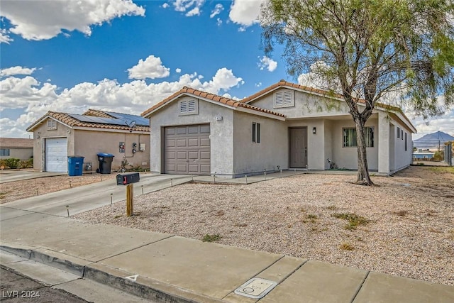 view of front of property with a garage and solar panels