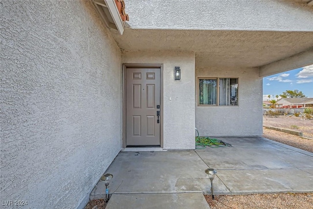 view of exterior entry featuring a patio