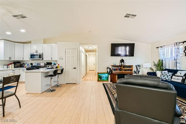 living room featuring light wood-type flooring and lofted ceiling