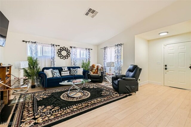 living room with vaulted ceiling and light hardwood / wood-style flooring