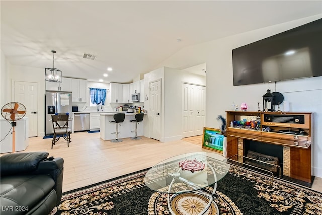 living room with a notable chandelier and light hardwood / wood-style flooring