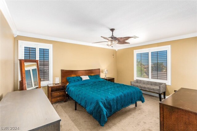 bedroom featuring ornamental molding, light colored carpet, and ceiling fan