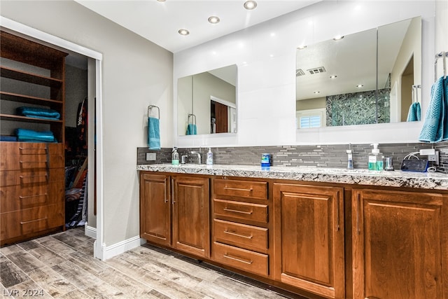 bathroom with dual bowl vanity, tasteful backsplash, and hardwood / wood-style floors