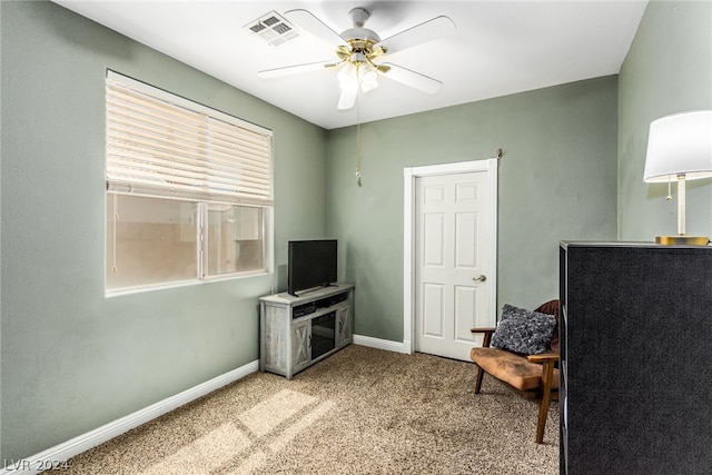 sitting room with ceiling fan and light colored carpet