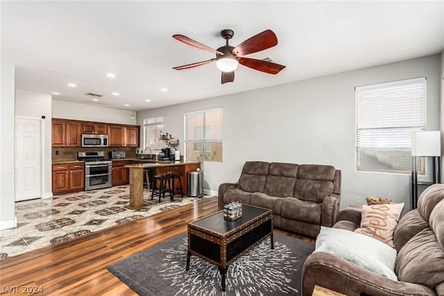 living room featuring hardwood / wood-style floors, sink, and ceiling fan