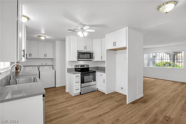 kitchen featuring sink, stainless steel appliances, washer and dryer, white cabinets, and light wood-type flooring