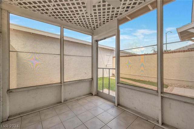 unfurnished sunroom featuring ceiling fan