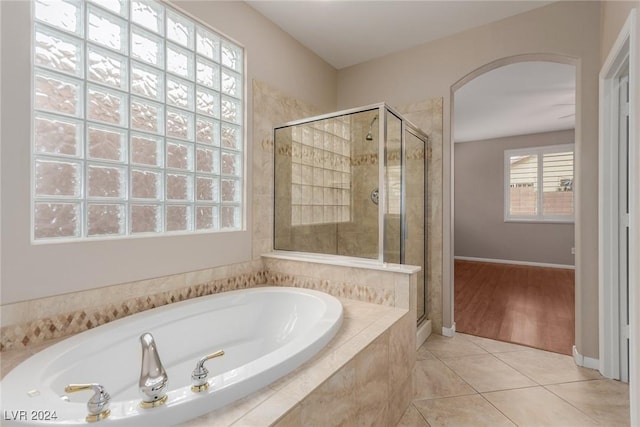 full bath featuring baseboards, a shower stall, a bath, and tile patterned floors