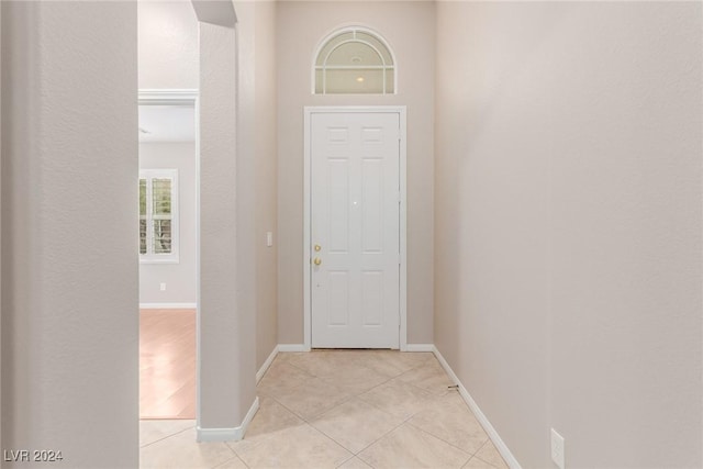 foyer entrance featuring light tile patterned floors and baseboards