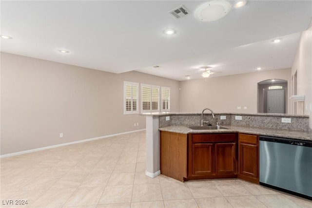 kitchen with arched walkways, visible vents, dishwasher, brown cabinets, and a sink