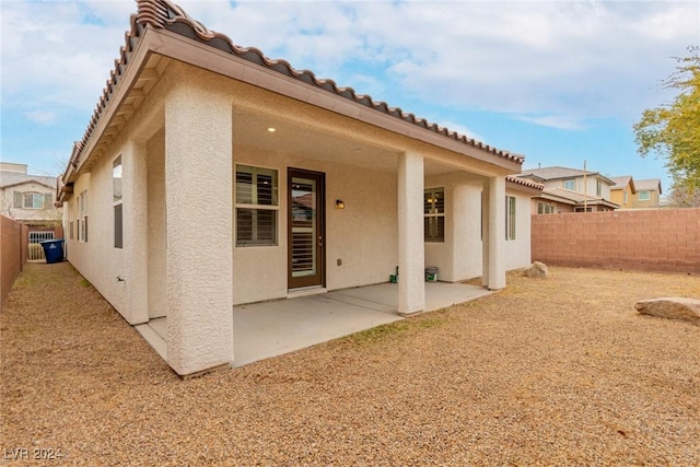 rear view of property with a patio area, a fenced backyard, and stucco siding