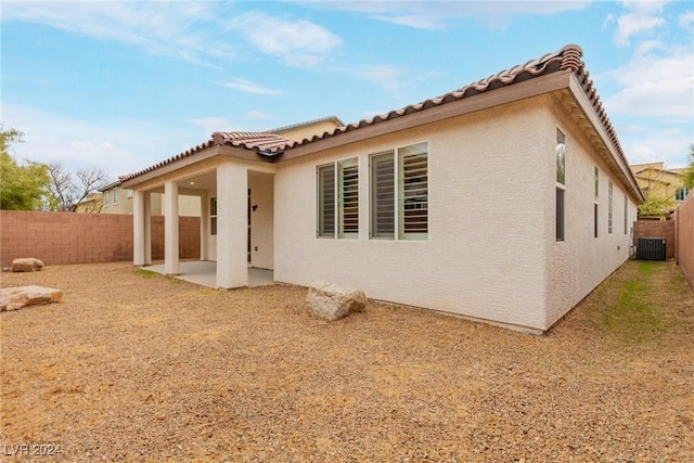 rear view of property featuring a patio, stucco siding, a fenced backyard, and central air condition unit