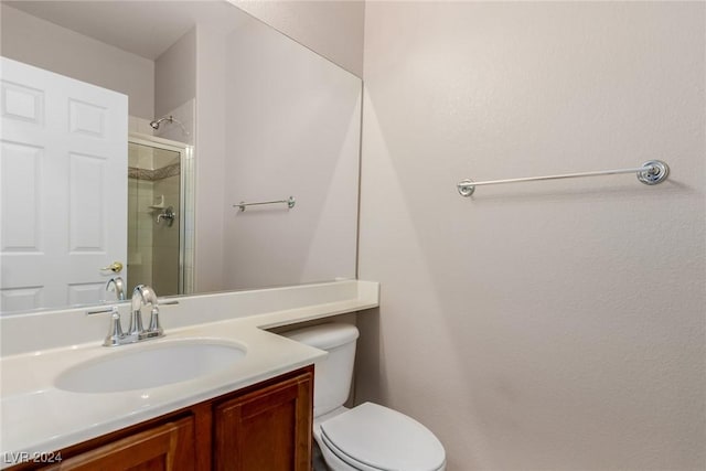 bathroom with a tile shower, vanity, and toilet