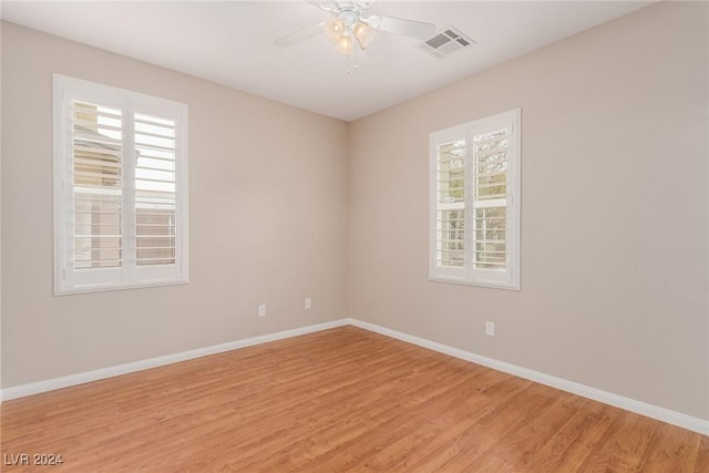 unfurnished room featuring light wood-style flooring, visible vents, and baseboards