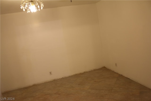 unfurnished room with tile patterned flooring and a notable chandelier