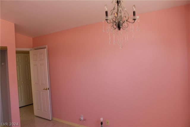 unfurnished bedroom featuring light tile patterned floors and a chandelier