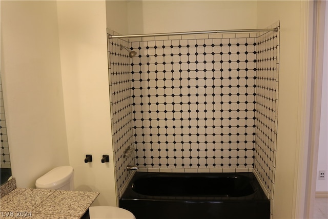 full bathroom featuring vanity, tiled shower / bath, and toilet