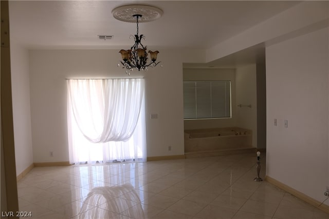 unfurnished room featuring a notable chandelier and light tile patterned floors