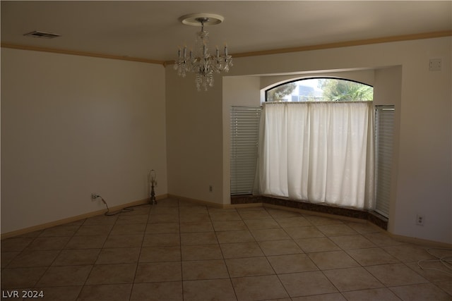 tiled spare room featuring ornamental molding and a chandelier