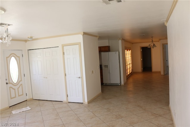 entrance foyer featuring ornamental molding, light tile patterned flooring, and a chandelier