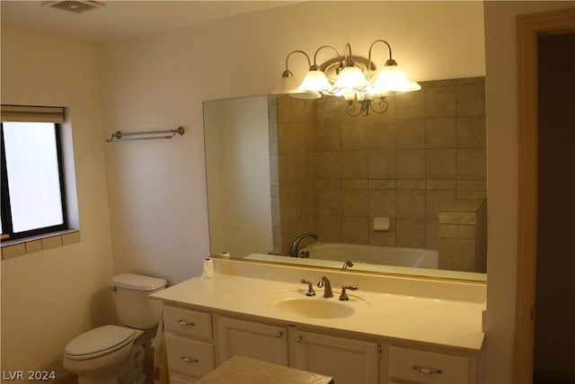 bathroom with vanity, toilet, and an inviting chandelier