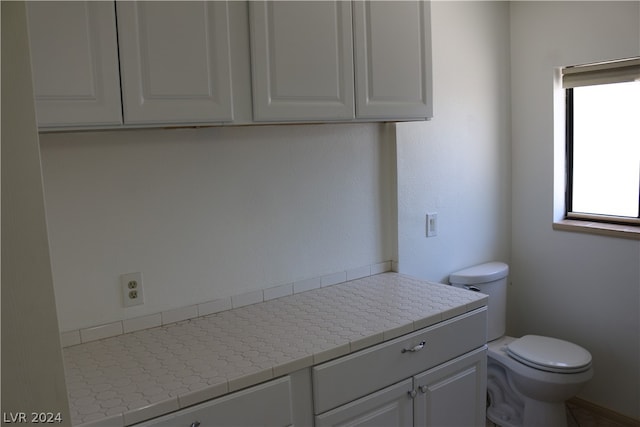 bathroom featuring vanity, tile patterned floors, toilet, and a wealth of natural light