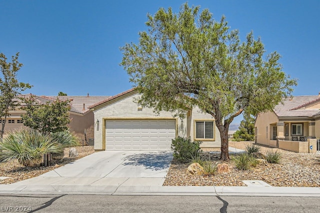 view of property hidden behind natural elements featuring a garage