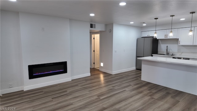 kitchen with sink, white cabinetry, pendant lighting, and dark wood-type flooring