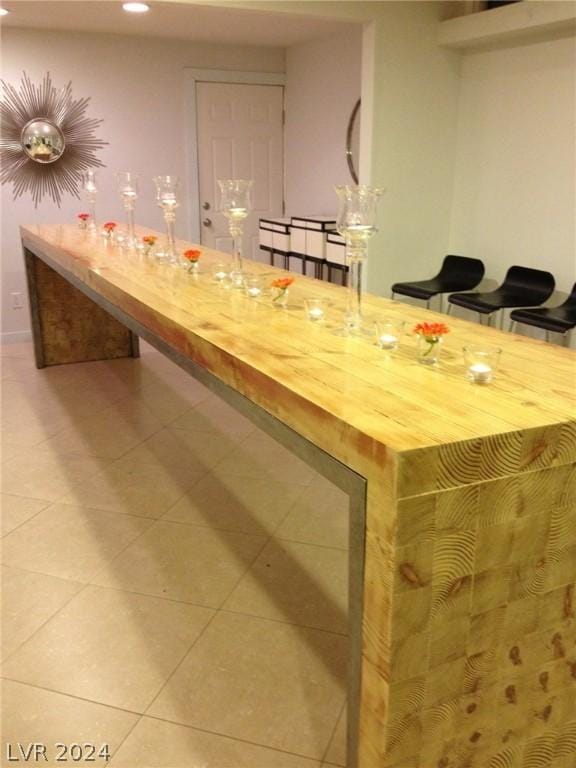 bar featuring tile patterned flooring and wooden counters