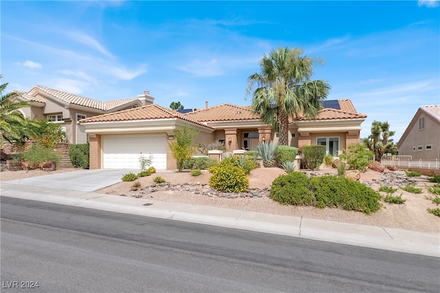 view of front of property featuring solar panels and a garage