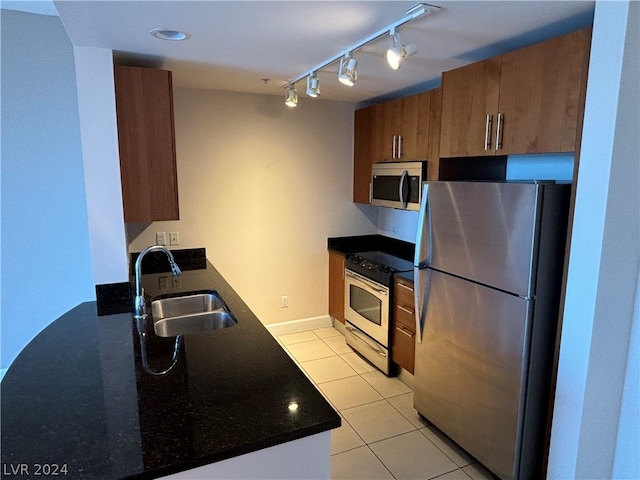 kitchen featuring light tile patterned flooring, sink, rail lighting, and stainless steel appliances