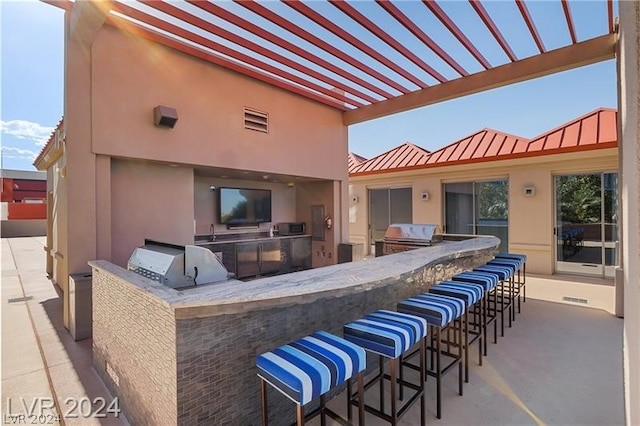 view of patio with an outdoor bar and an outdoor kitchen