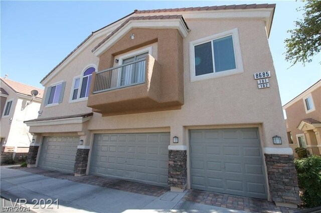 multi unit property featuring a garage and a balcony