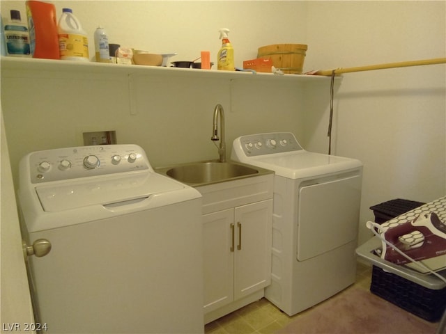 laundry room featuring cabinets, sink, light tile patterned flooring, and washing machine and clothes dryer