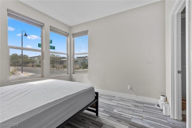 bedroom with wood-type flooring and multiple windows