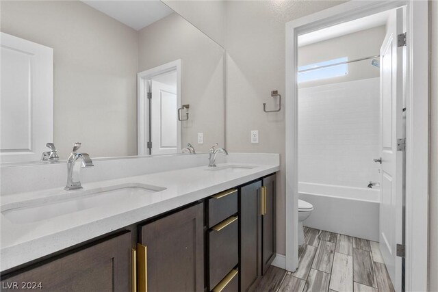 full bathroom with bathtub / shower combination, toilet, and dual bowl vanity